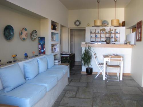 a living room with a blue couch and a table at Thea Home Hotel by Booking Kottas in Skopelos Town