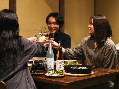 a group of people sitting around a table with wine glasses at RITA Izumo Sagiura in Izumo