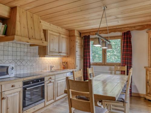 une cuisine avec des armoires en bois et une table avec des chaises dans l'établissement Appartement 3 Chambres à Megève - Proche Centre, Balcon, Garage, Animaux Acceptés - FR-1-453-312, à Megève