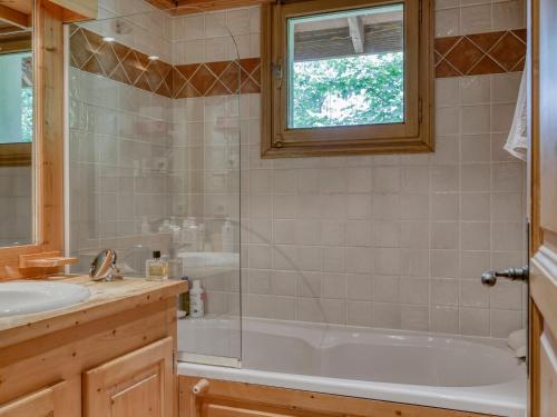 une salle de bain avec une baignoire et un lavabo dans l'établissement Appartement 3 Chambres à Megève - Proche Centre, Balcon, Garage, Animaux Acceptés - FR-1-453-312, à Megève