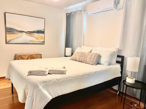 a bedroom with a white bed with towels on it at Charming downtown home by bike trail, river and coffee! in Redding