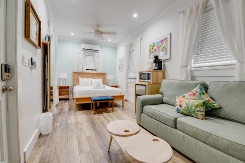 een woonkamer met een bank en een bed bij Harbor Walk Hideaways in Key West