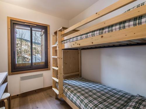 una camera da letto con due letti a castello e una finestra di Appartement 3 chambres au centre de Megève avec terrasse et Wifi - FR-1-453-316 a Megève