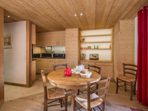 une cuisine et une salle à manger avec une table et des chaises en bois dans l'établissement Appartement 3 chambres au centre de Megève avec terrasse et Wifi - FR-1-453-316, à Megève