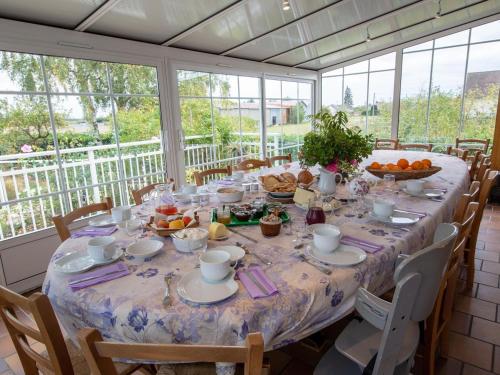 - une longue table avec de la nourriture dans une chambre avec des fenêtres dans l'établissement Suite familiale confortable avec WiFi à Saint-Benoît-sur-Loire, animaux admis - FR-1-590-447, à Saint-Benoît-sur-Loire