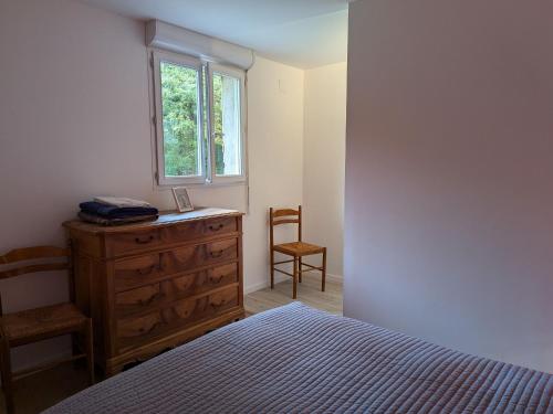 a bedroom with a bed and a dresser and a window at Gîte Authentique à Villemurlin avec Jardin et Parking - FR-1-590-527 in Villemurlin