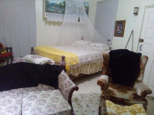 a bedroom with a bed and two chairs at Captain Morgan House in Kingston