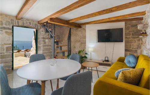 un salon avec une table blanche et un canapé jaune dans l'établissement Awesome Home In Jesenice With Kitchen, à Jesenice