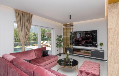 a living room with a red couch and a tv at Stunning Home In Zagvozd With Sauna in Zagvozd