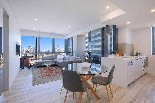 a kitchen and a living room with a table and chairs at Sundale at Southport - Resort-style Panorama in Gold Coast
