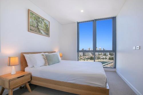 a bedroom with a bed and a large window at Sundale at Southport - Resort-style Panorama in Gold Coast