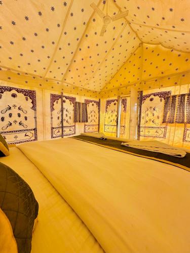 a large room with a bed in a tent at Golden Heaven Desert Camp in Jaisalmer