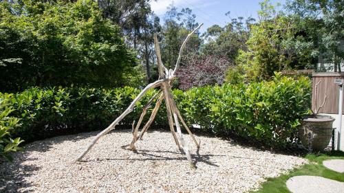a metal sculpture of a person in a garden at Luxury Beach Shack With Pool and Short Walk To Beach in Macmasters Beach