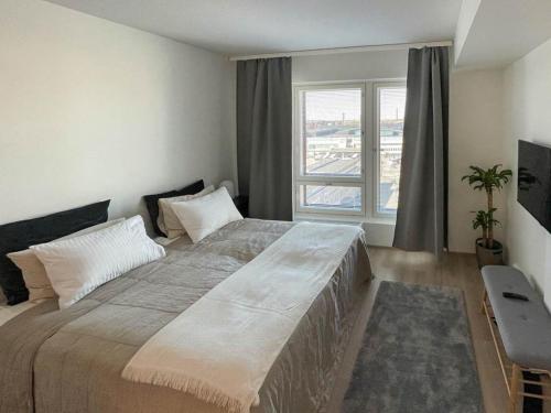 a bedroom with a large bed with a large window at StyleStudio Areena1 in Tampere
