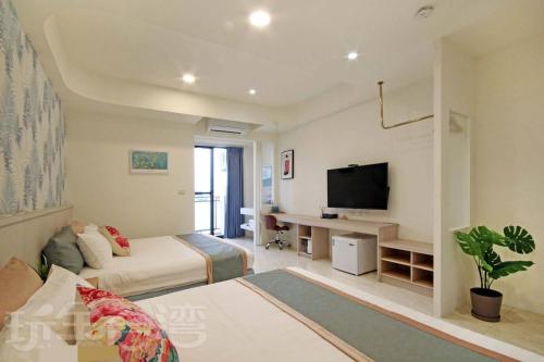 a bedroom with a bed and a tv in a room at Station Sea B&B in Fangliao