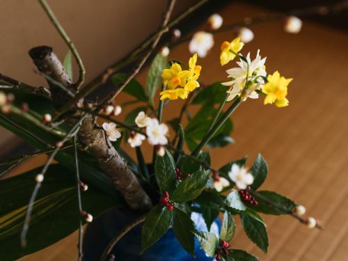 a vase with yellow and white flowers in it at RITA Izumo Sagiura in Izumo