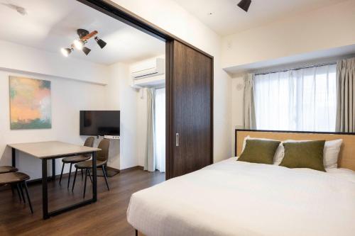 a bedroom with a bed and a table and a desk at The Parkcross Ryogoku Midori in Tokyo