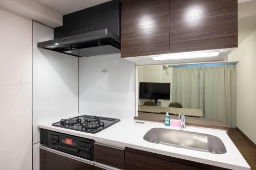 a kitchen with a sink and a stove at The Parkcross Ryogoku Midori in Tokyo