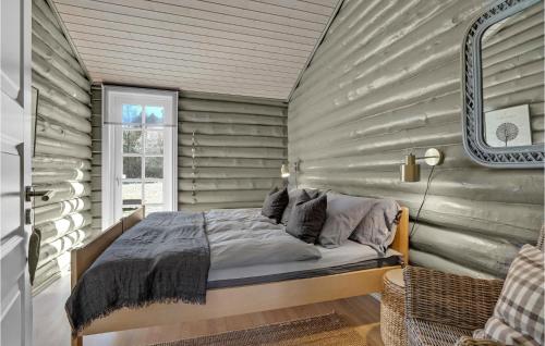 a bedroom with a bed in a room with wooden walls at 3 Bedroom Amazing Home In Sæby in Sæby