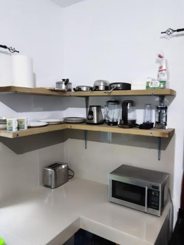 a kitchen with wooden shelves and a microwave at Sea Beach Escape & Vacation Rental in Negril