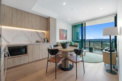 a kitchen and living room with a table and chairs at Serain Residences Next to Casino Gold Coast in Gold Coast