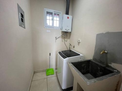 un bagno bianco con lavandino e finestra di Casa Colibrí, entera, Volcán a Volcán