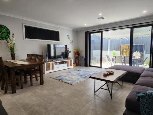 a living room with a couch and a table and a television at Minutes to the Beach! King Bed with TV, Spa Bath in Christies Beach