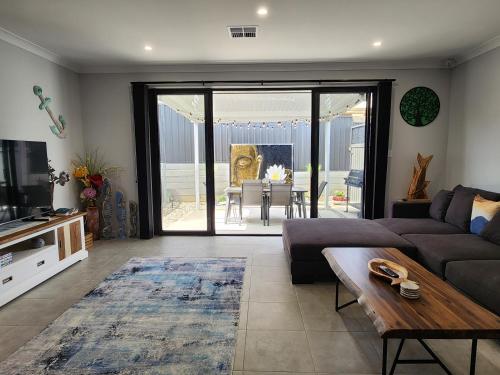 a living room with a couch and a table at Minutes to the Beach! King Bed with TV, Spa Bath in Christies Beach