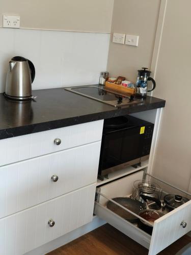 a kitchen with a sink and a microwave at Braxmere Lodge in Turangi