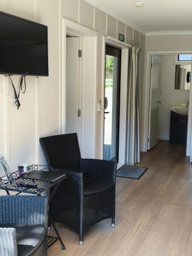 a living room with a couch and a chair and a television at Braxmere Lodge in Turangi