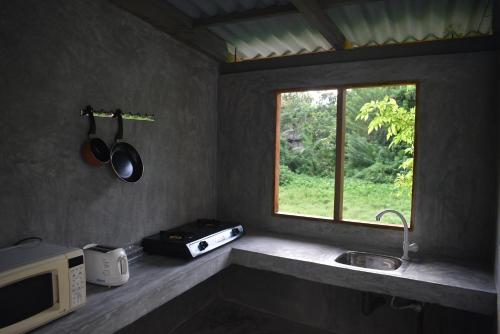 a kitchen with a microwave and a sink and a window at Villa Shiny Aura - Hikkaduwa in Hikkaduwa