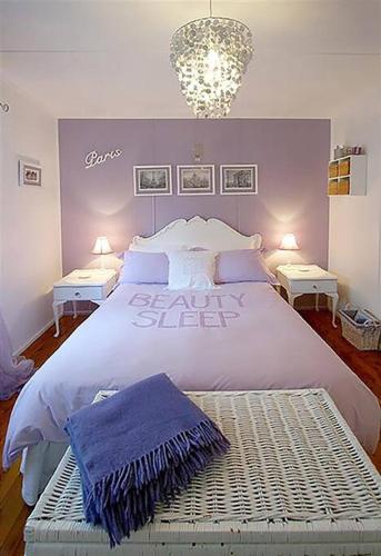 a bedroom with a large white bed with purple walls at Laguna Blue Beach House-WIFI-Beach Access in Hyams Beach