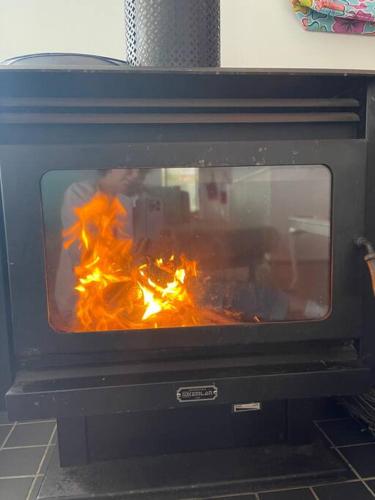 a fire inside of an oven with flames in it at Laguna Blue Beach House-WIFI-Beach Access in Hyams Beach