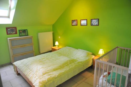 a green bedroom with a bed and a crib at Cote Vue in Grandhan