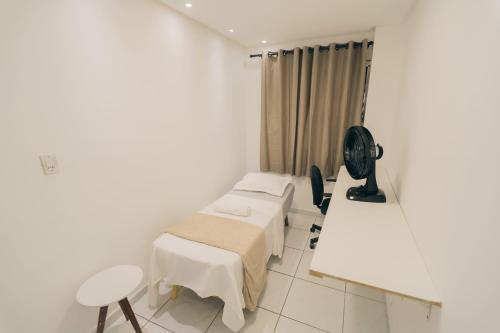 ein Krankenhauszimmer mit einem Bett und einem Ventilator in der Unterkunft Grande Apartamento Com 3 Quartos e Uma Localização Privilegiada in Campina Grande