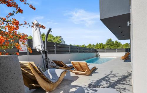 patio con sedie e ombrellone accanto alla piscina di Pet Friendly Home In Vodice With Sauna a Vodice