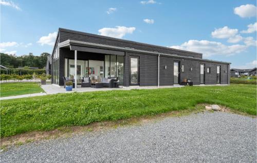 a black house with a large yard at Three-Bedroom Holiday Home In Haderslev in Haderslev