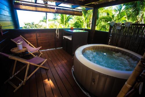 a hot tub on a deck with a table and chairs at OHANA Jungle Lodges in Les Avirons
