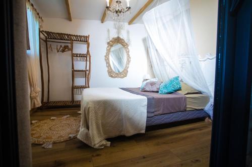 a bedroom with a bed and a mirror at OHANA Jungle Lodges in Les Avirons