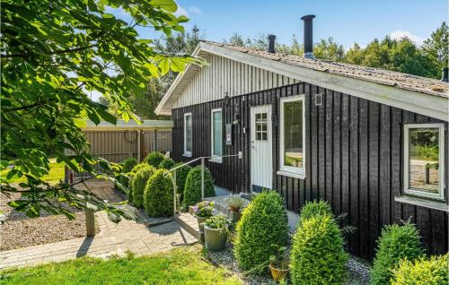 a black tiny house with a garden at Three-Bedroom Holiday Home In Thyholm in Thyholm