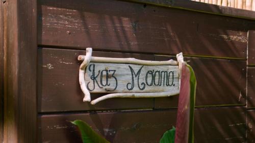 a sign on the side of a wooden wall at OHANA Jungle Lodges in Les Avirons