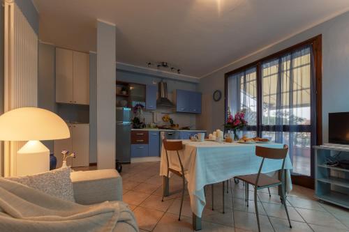 cocina y sala de estar con mesa y sillas en Bellavista Apartment, en Marina di Ravenna