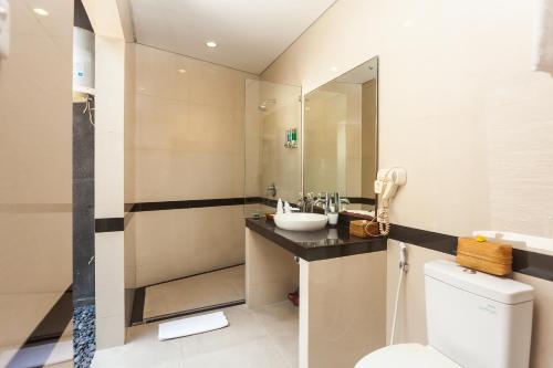 a bathroom with a sink and a toilet and a mirror at Kadiga Villas Ubud by GenuineHost in Ubud