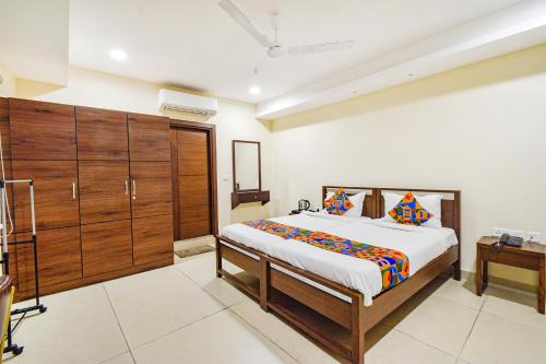 1 dormitorio con 1 cama grande y armarios de madera en FabHotel Prime AM Suites - Nr Secunderabad Railway Satation, en Hyderabad