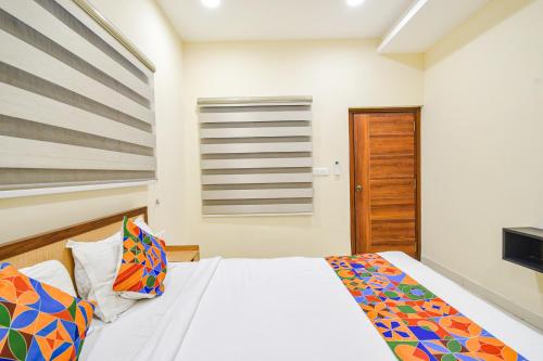 a bedroom with a bed and a window at FabHotel Prime AM Suites - Nr Yashoda Hospitals in Hyderabad