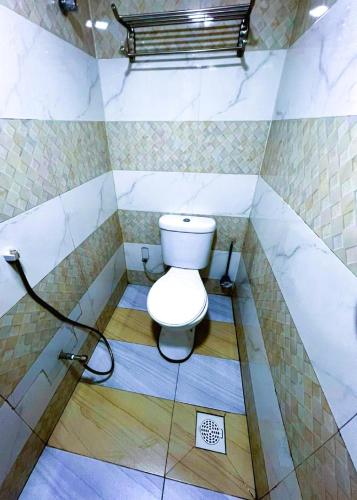 a bathroom with a white toilet in a room at ARK Hotel New Wave Shah Alam in Shah Alam