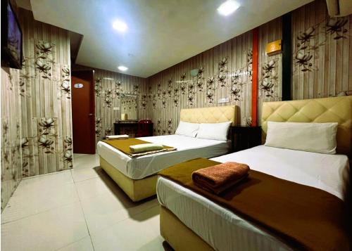 a hotel room with two beds and a couch at ARK Hotel New Wave Shah Alam in Shah Alam