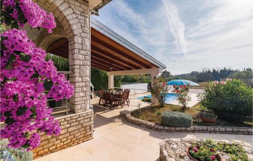 a house with a patio with purple flowers at Holiday Home Krse V in Premantura