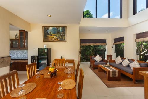 a living room with a table and a couch at Kadiga Villas Ubud by GenuineHost in Ubud