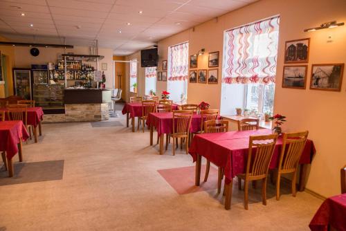 un restaurant avec des tables, des chaises et des nappes rouges dans l'établissement Ankur Hotell, à Mustvee